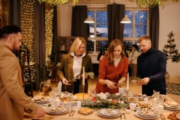 Family setting a festive table for Christmas dinner in a cozy, decorated home.