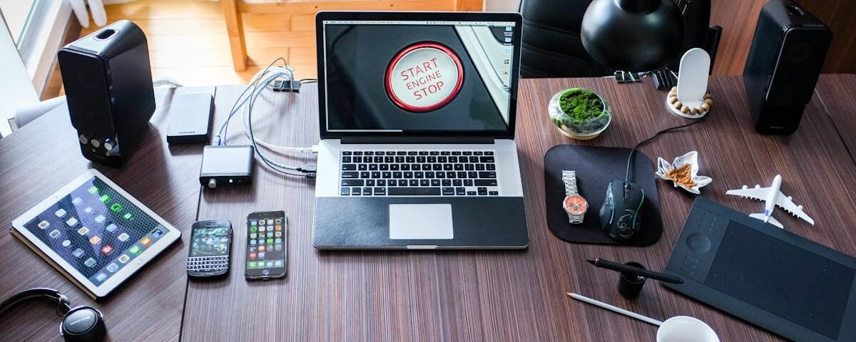 A contemporary office desk setup with laptops, gadgets, and accessories, creating a tech-savvy workplace.