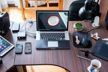 A contemporary office desk setup with laptops, gadgets, and accessories, creating a tech-savvy workplace.