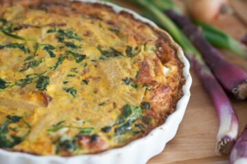 Delicious homemade quiche with fresh red onions and spinach, perfect for a tasty meal.