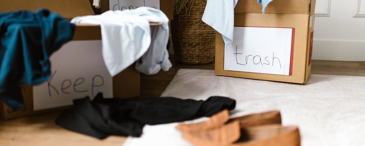 Decluttering concept using labeled boxes for sorting clothes in a home setting.