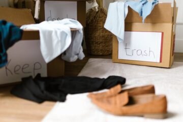 Decluttering concept using labeled boxes for sorting clothes in a home setting.
