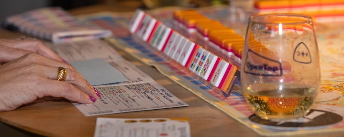 Engaging game night scene with friends playing mahjong and enjoying drinks. Perfect social moment.