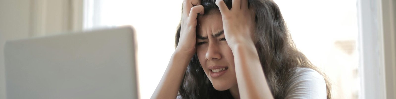 Frustrated woman struggling with remote work stress and digital challenges indoors.