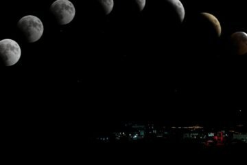 Captivating lunar eclipse sequence featuring blood moon over cityscape.