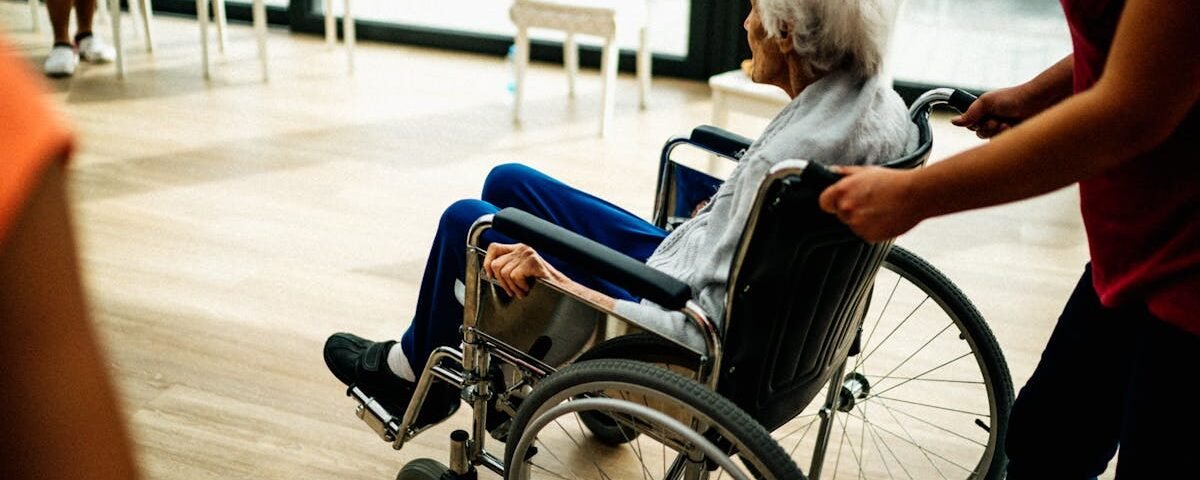 A caregiver assists a senior adult in a wheelchair at a nursing home in Prague, Czech Republic.