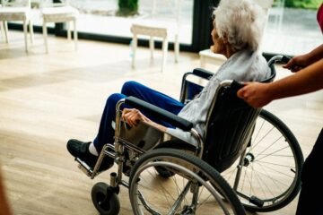 A caregiver assists a senior adult in a wheelchair at a nursing home in Prague, Czech Republic.