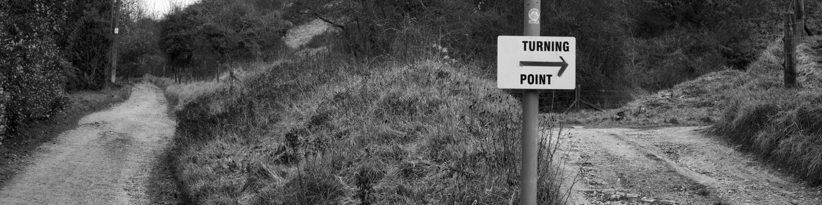 Black and white photo of a turning point in the Cheltenham countryside with directional signs.