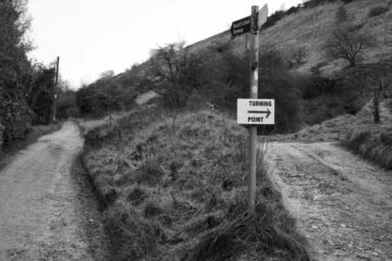 Black and white photo of a turning point in the Cheltenham countryside with directional signs.