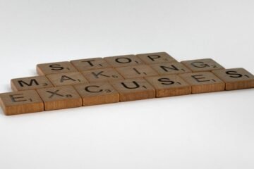 Inspirational phrase "Stop making excuses" crafted with wooden letter tiles.